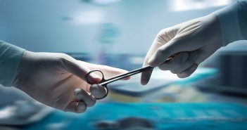 healthcare and medical concept , Close-up of surgeons hands holding surgical scissors and passing surgical equipment , motion blur background.