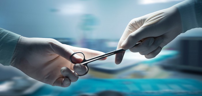 healthcare and medical concept , Close-up of surgeons hands holding surgical scissors and passing surgical equipment , motion blur background.